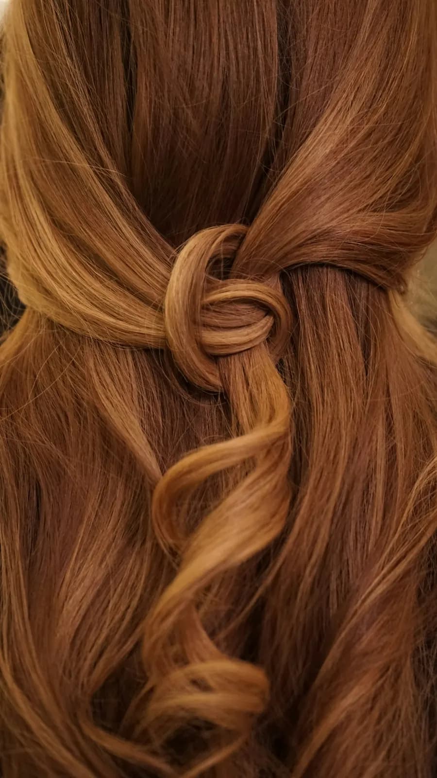Auburn waves with the sides pulled back and knotted into a twist