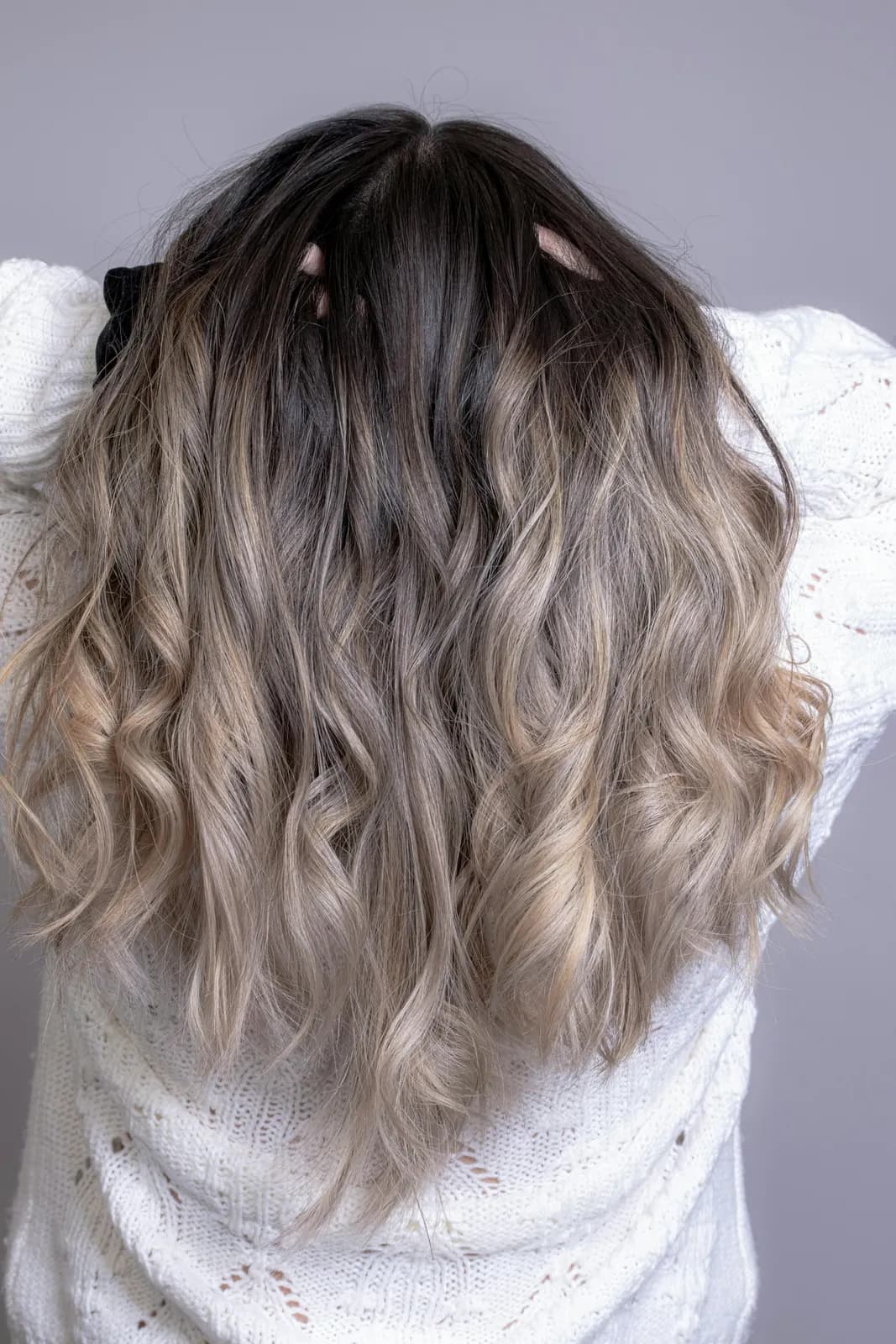 Long waves seen from behind, dark at the roots and melting into ash blonde